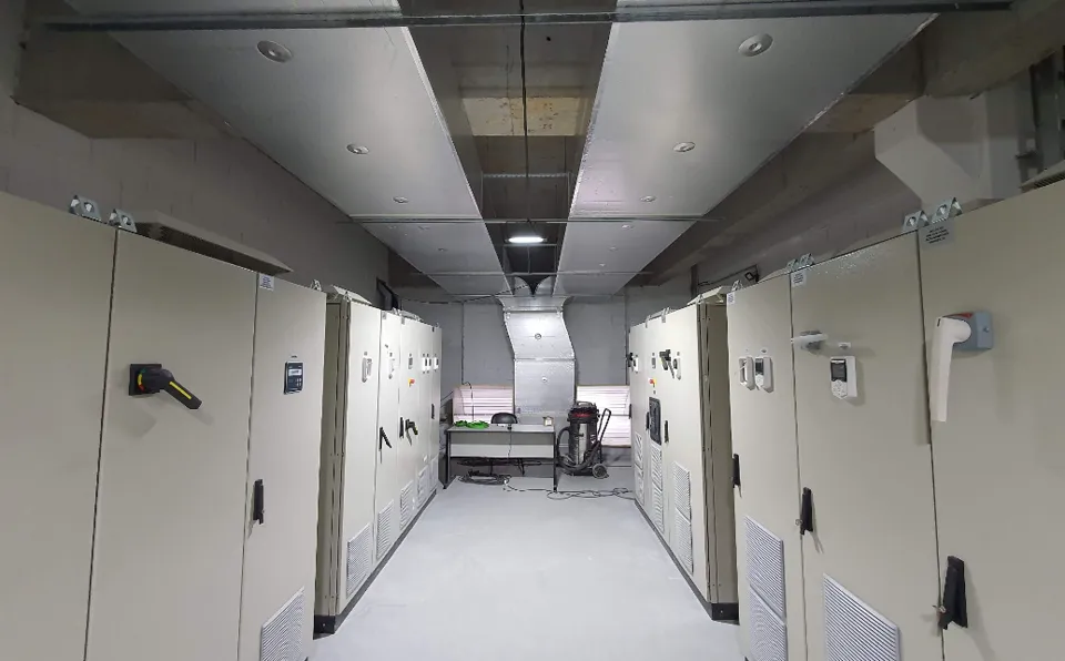 Photo of an electrical panel room with overhead cooling ductwork
