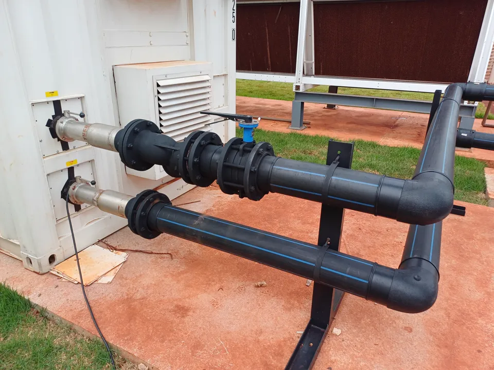 Photo of dual HDPE hot and cold water piping loops connecting to a dry cooler unit on site