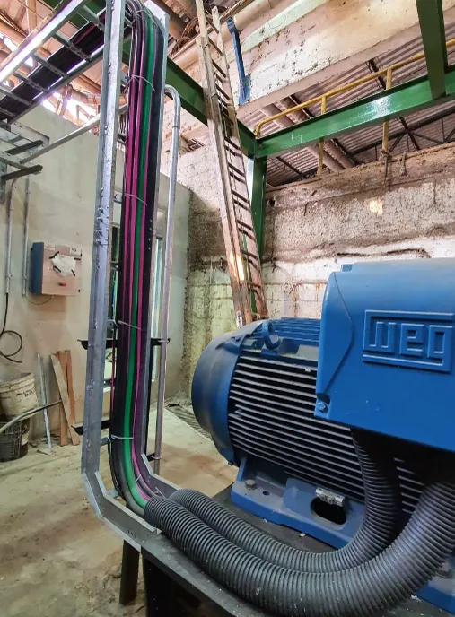 Photo of an industrial electric motor with cable tray routing in a factory setting
